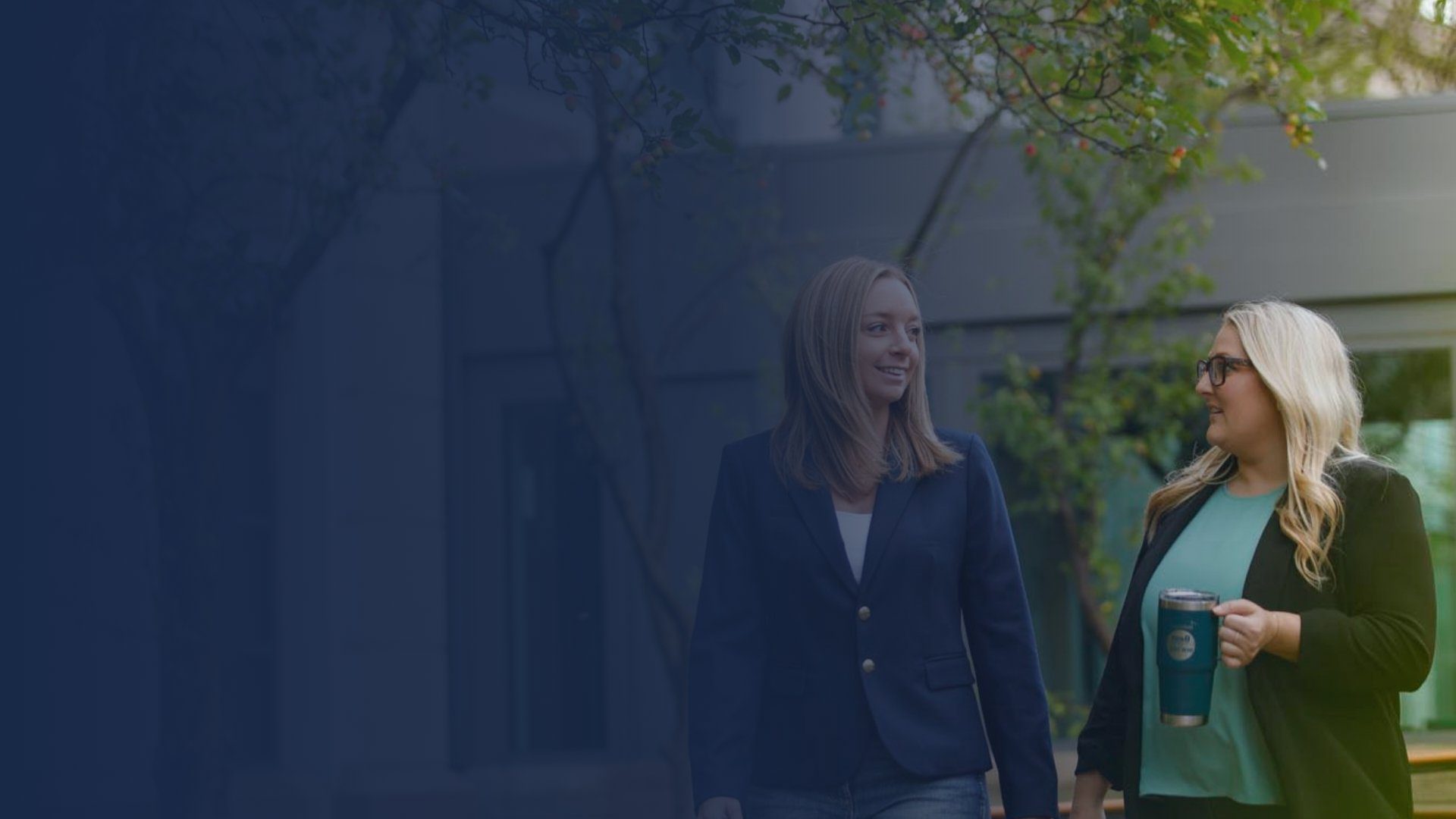 Two business women walking outside talking